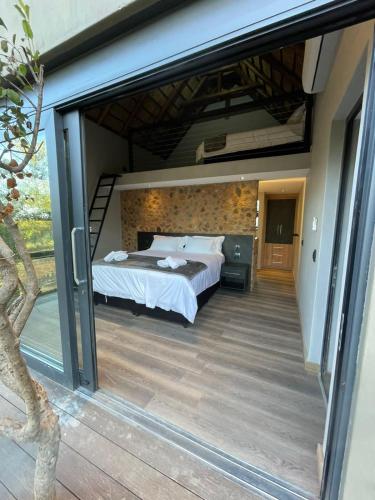 a bedroom with a bed and a large window at Tadima Lodge Mabalingwe in Mabula