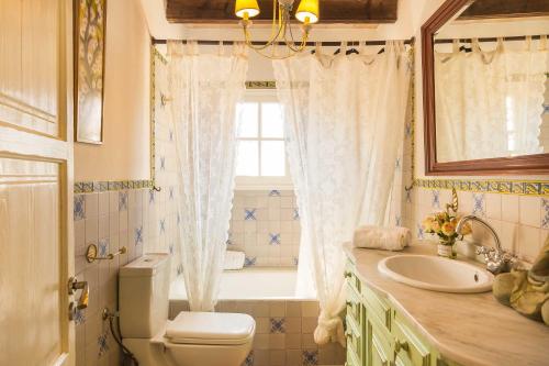 une salle de bain avec toilettes, lavabo et fenêtre dans l'établissement Casa Eva, à Mancor del Valle