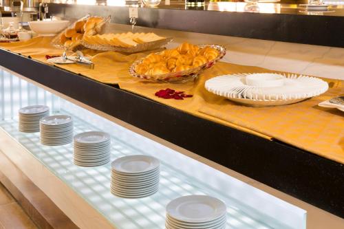 ein Buffet mit Tellern und Gerichten auf dem Tisch in der Unterkunft Galina Hotel & Spa in Nha Trang