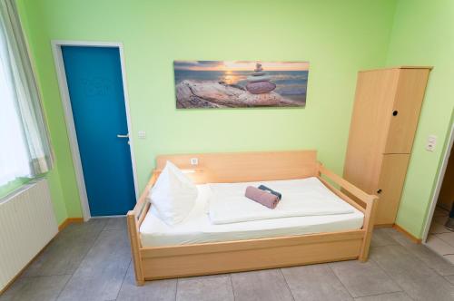 a bed in a room with a blue door at Radfahrerherberge Krems in Krems an der Donau