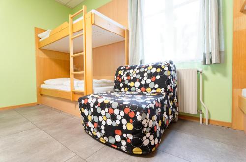 a room with a chair and a bunk bed at Radfahrerherberge Krems in Krems an der Donau