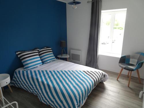 a bedroom with a bed with blue walls and a window at Appartement Petite Auberge in Saint-Jean-dʼAssé