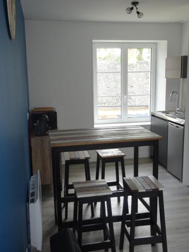 a kitchen with a wooden table and four stools at Appartement Petite Auberge in Saint-Jean-dʼAssé