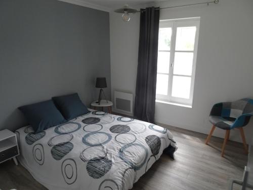 a bedroom with a bed and a window and a chair at Appartement Petite Auberge in Saint-Jean-dʼAssé