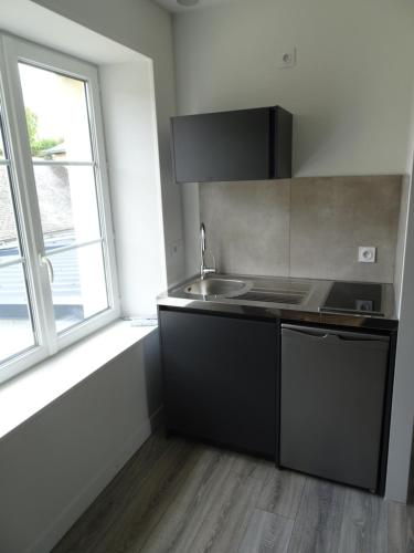 a kitchen with a sink and a window at Appartement Petite Auberge in Saint-Jean-dʼAssé