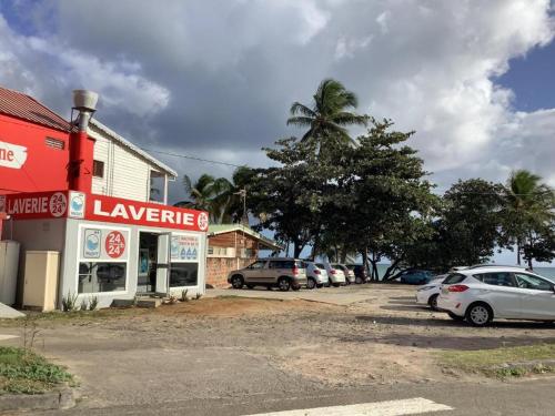 a parking lot with cars parked in front of a building at Ti-CHERRY in Le Diamant