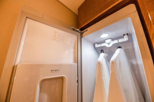 um pequeno frigorífico com cortinas brancas num quarto em Hotel the Hill em Gwangju