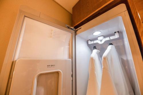 a small refrigerator with white curtains in a room at Hotel the Hill in Gwangju
