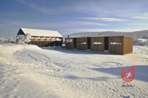 a building covered in snow with footprints in the snow at Apartmány Sport Malá Úpa in Horní Malá Úpa