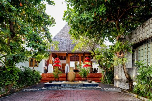 a house with a fountain in the middle of a courtyard at Villa Kayu Raja in Seminyak