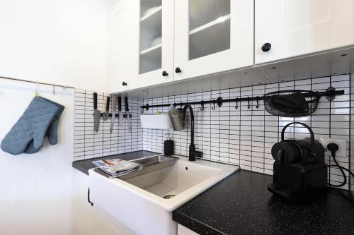 a kitchen with a sink and a black counter top at Le Schuss Tignes, appartement cosy 4 personnes in Tignes