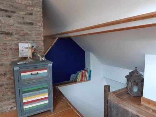 a attic room with a dresser and a blue wall at St Elme, maison de pêcheurs, WIFI jardin in Ault