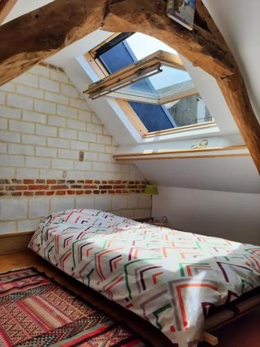 une chambre avec un lit dans un grenier dans l'établissement St Elme, maison de pêcheurs, WIFI jardin, à Ault