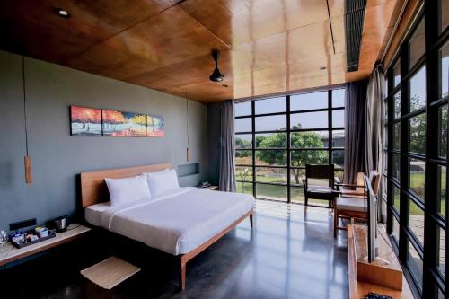 a bedroom with a bed and a large window at Beyond by Sula in Nashik