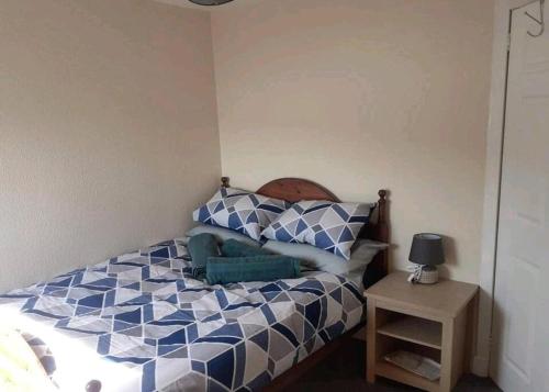 a bedroom with a blue and white bed and a table at Inviting 1-Bed Apartment in Campbeltown Loch views in Campbeltown