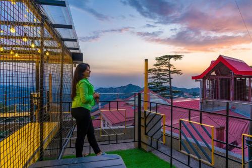 una mujer parada en la parte superior de una estructura de juego en The Hosteller Shimla en Shimla