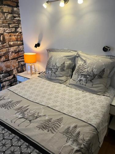 - une chambre dotée d'un lit avec des draps gris et blancs dans l'établissement Le Schuss Tignes, appartement cosy 4 personnes, à Tignes