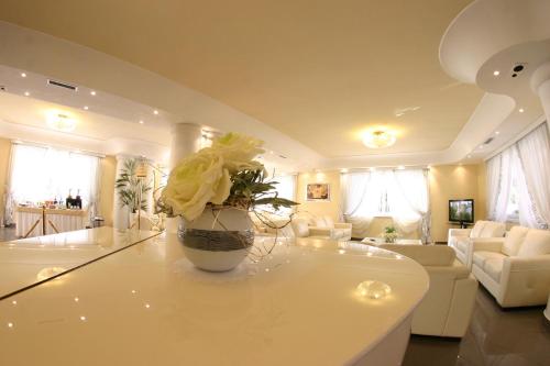 a living room with a vase of flowers on a counter at Hotel Luxor in Casoria