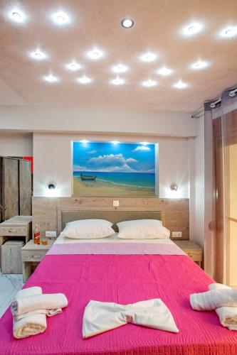 a bedroom with a large bed with a pink blanket at RENT HOUSE ANEMOS in Iraklitsa