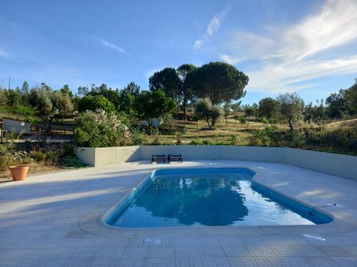 una piscina con un banco en un patio en Vale de Garcia en Colos