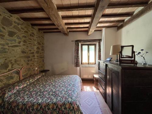 a bedroom with a bed and a stone wall at Agriturismo Bio I Rondinelli in Arcidosso