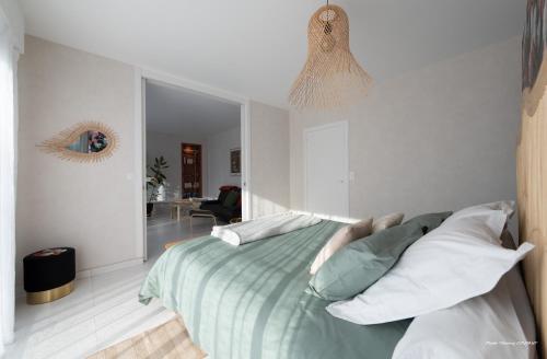 - une chambre avec un lit et des oreillers blancs dans l'établissement Agapè, élégant T2, 4 étoiles, plage et GR34 3km, centre ville 750m, à Fouesnant