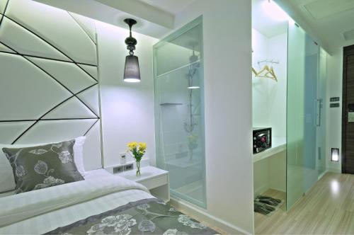 a bedroom with a glass shower and a bed at Sukhumvit Suites Hotel in Bangkok