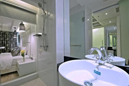 a bathroom with a sink and a mirror at Sukhumvit Suites Hotel in Bangkok