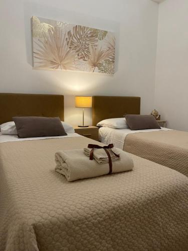 a room with two beds with towels on them at Taormina Family Apartment in Taormina