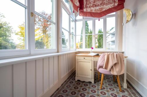 a home office with a desk and windows at Hotel Garni Villa Rosengarten in Überlingen