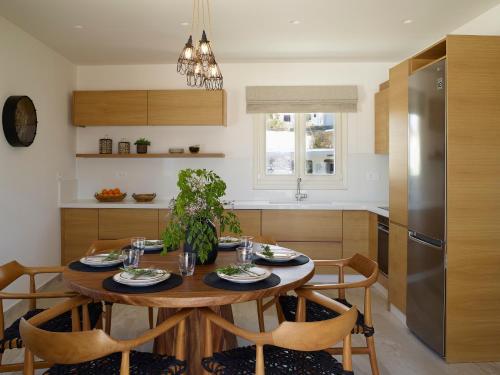a kitchen with a wooden table and chairs in a kitchen at Vencia Boutique Hotel in Mikonos