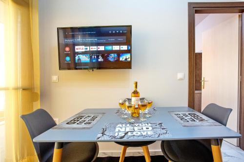 a dining room with a blue table and a tv at RENT HOUSE ANEMOS in Iraklitsa