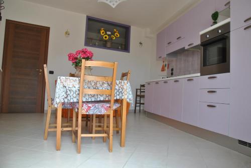 a kitchen with a table and chairs in a room at Appartamenti Elisa in Assisi