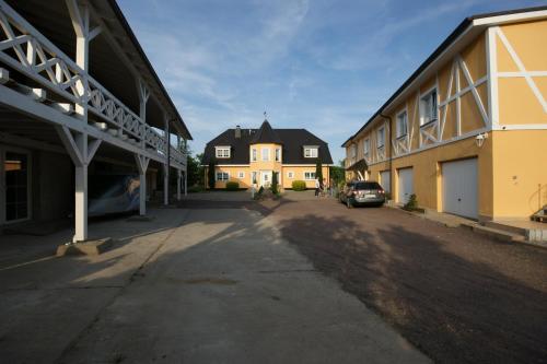 an empty street with two buildings and a car at Ferienhof Elbaue in Schönebeck
