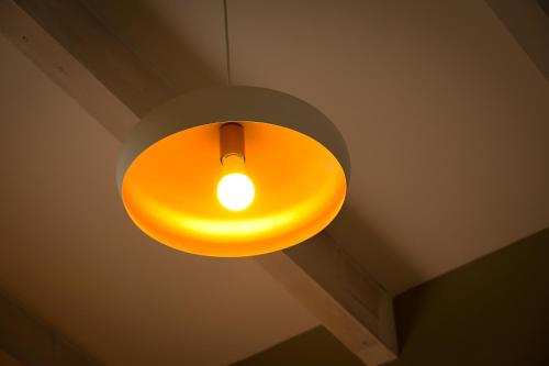 a yellow light hanging from a ceiling at Tslil Suite in Yeroẖam