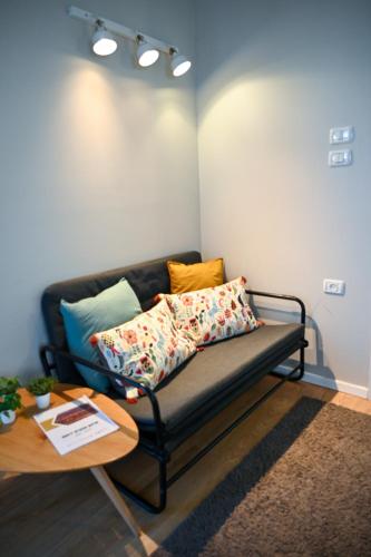 a couch in a living room with a table at Tslil Suite in Yeroẖam
