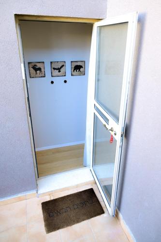 an open door with a mirror in a room at Tslil Suite in Yeroẖam