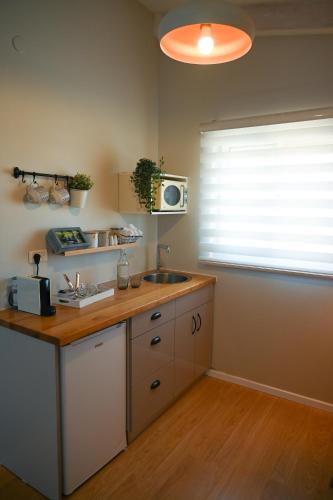 a kitchen with a counter and a sink and a window at Tslil Suite in Yeroẖam