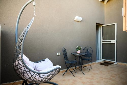 a hanging chair in a room with a table at Tslil Suite in Yeroẖam