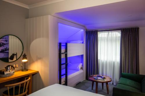 a hotel room with a bedroom with a bed and a desk at North Lakes Hotel and Spa in Penrith