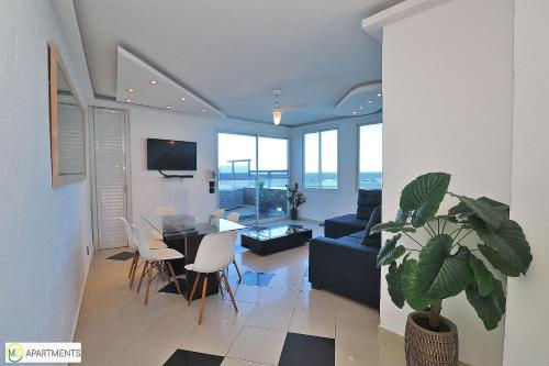 sala de estar con sofá, mesa y sillas en Incrivel cobertura de frente para o mar com 3 quartos e piscina particular em Copacabana!, en Río de Janeiro
