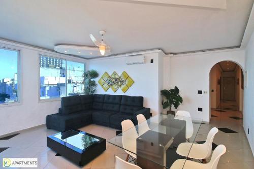 sala de estar con sofá y mesa de cristal en Incrivel cobertura de frente para o mar com 3 quartos e piscina particular em Copacabana!, en Río de Janeiro
