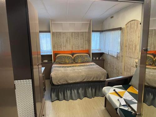 a small bedroom with a bed in a trailer at La Caravane LE NID DOUILLET in Ponte-Leccia