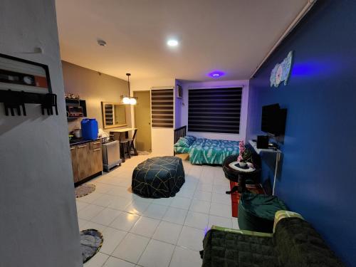 Chichi's Snug Pad near Enchanted Kingdom and Nuvali في Santa Rosa: غرفة معيشة مع أريكة وسرير