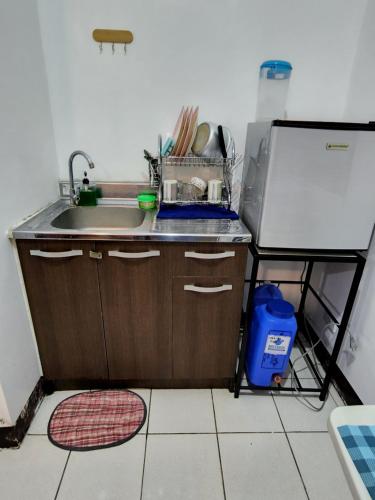 uma pequena cozinha com um lavatório e um frigorífico em Ilia's Cozy Abode near Enchanted Kingdom & Nuvali em Santa Rosa