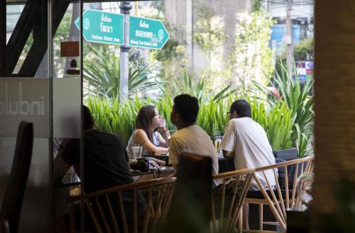 a group of people sitting at a table in a restaurant at Sukhumvit Suites Hotel in Bangkok