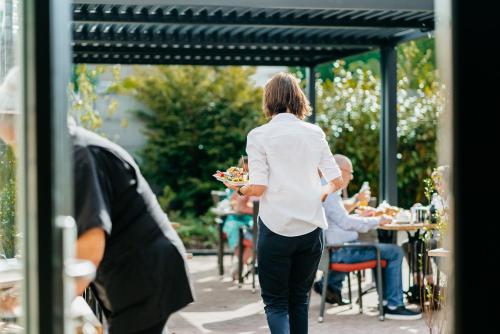a woman is holding a plate of food at Hotel Janssen in Valkenburg