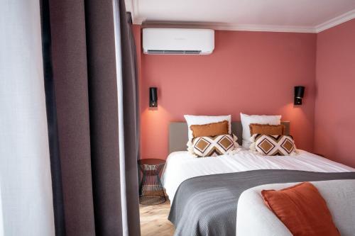 two beds in a room with red walls at Hotel Janssen in Valkenburg