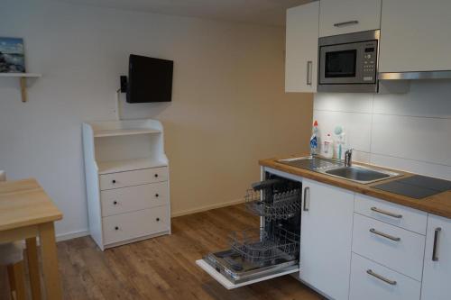 a small kitchen with a sink and a dishwasher at Café Canapé Ravensburg - nahe Bodensee & Messe in Ravensburg