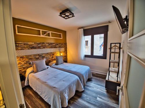 a bedroom with two beds and a window at Apartamentos Valle de Ordesa-Torla in Torla-Ordesa